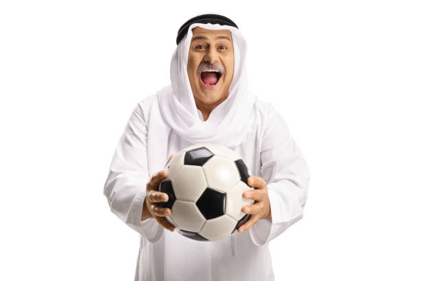 Excited mature muslim man in white dishdasha holding soccer ball Excited mature muslim man in white dishdasha holding soccer ball isolated on white background mullah photos stock pictures, royalty-free photos & images