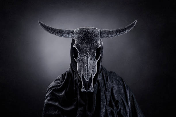 figura raccapricciante con teschio animale con corna al buio - goat skull foto e immagini stock