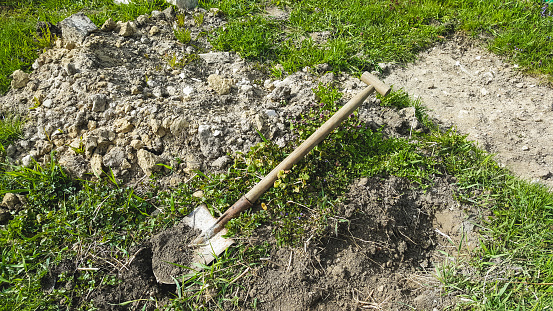 Shovel lying on green grass. Gardening tool. Seasonal work in the garden.