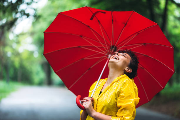 istock Woman laughing in park at rain 1317973406