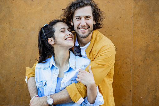 Portrait of young couple outdoors, smiling and looking at camera