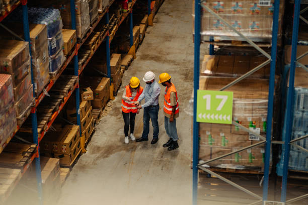 istock Three business people with safety helmet at warehouse 1317976491