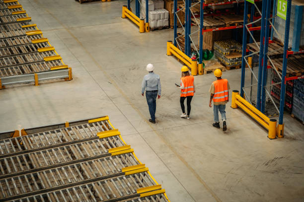 istock Warehouse employees walking through shelves and talking 1317976507