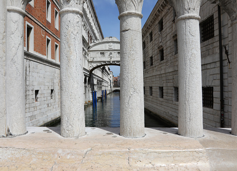 stone balustrade and in the background the famous bridge of sighs in Venice in Italy and the canal below