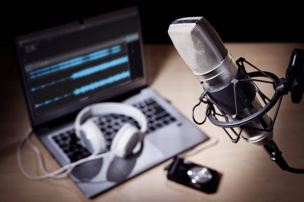 Podcast microphone and laptop computer in recording studio Podcast microphone, laptop computer camera and headphones on desk in recording studio live broadcast photos stock pictures, royalty-free photos & images