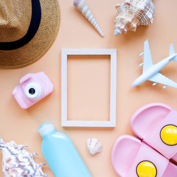 istock Summer background. Sun hat, camera, slippers, sunscreen, seashells, model airplane, and frame. Travel and summer vacation concept. 1317981657