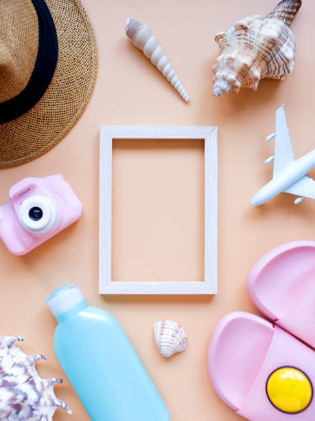 istock Summer background. Sun hat, camera, slippers, sunscreen, seashells, model airplane, and frame. Travel and summer vacation concept. 1317981659