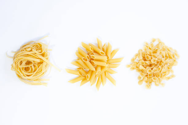 istock Various uncooked pasta on white background. Top view. Raw pasta with ingredients for cooking. Food concept 1317981667