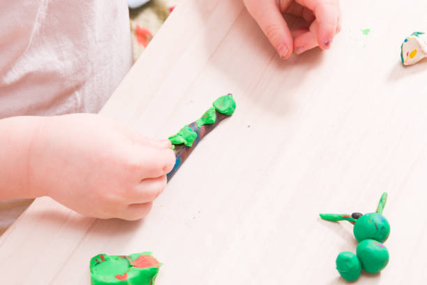 istock a small child sculpts from plasticine, a wooden light table, classes with a child at home, how to develop fanstasia in a child, games at home for small children 1317985474