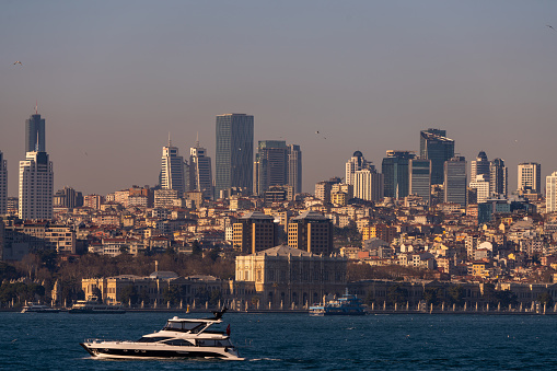 Istanbul cityscape, skyscrapers and Dolmabahce Palace view from Bosporus strait. March 2021