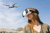 woman flying a drone wearing VR goggles