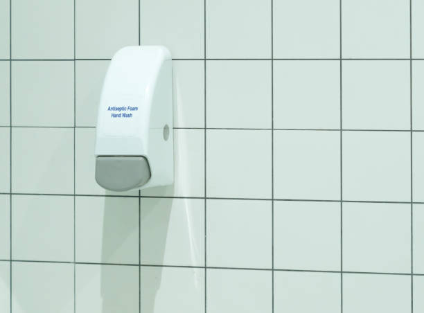 istock Automatic drug distribution arm, vending machine, antiseptic foam dispenser sticking on the toilet or restroom wall to dispense antiseptic foam to sterilize customers’ hands or kill germs in their hands in order to protect them against covid-19, coronavi 1317987512