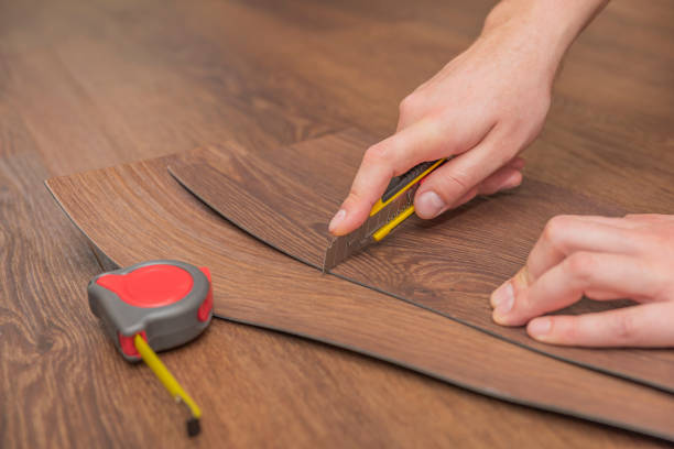 istock DIY vinyl flooring. Easy installation and cutting with a knife, Master cuts vinyl plank before installation, brown heated floor. Copy space 1317988327