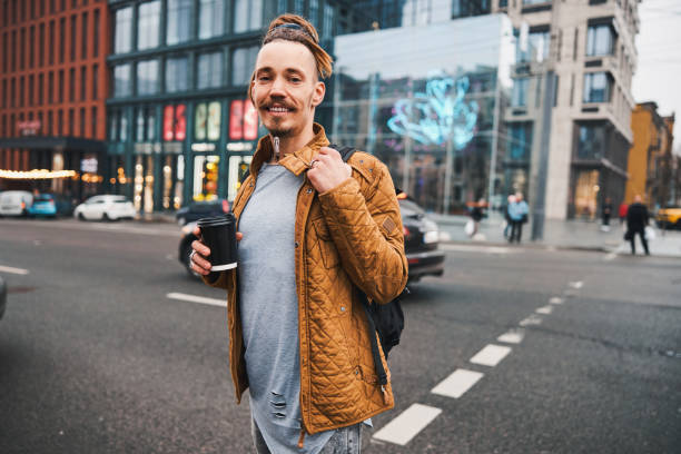 istock Joyful young man crossing road in downtown 1317990020