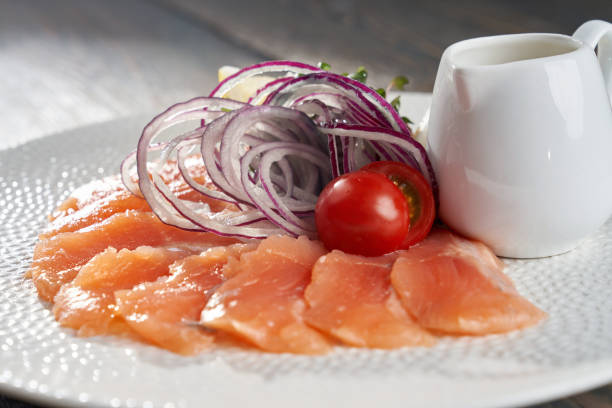 istock Raw salmon slices with lemon, onion, oil. 1317990051