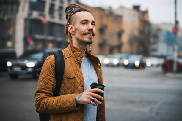 istock Smiling handsome hipster walking alone in city 1317990057