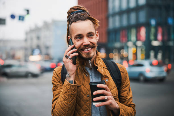 istock Smiling handsome hipster speaking on smartphone outdoors 1317990059