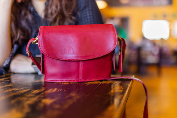 rote handtasche auf vintage-optigem restauranttisch mit verschwommenem hintergrund - food currency breakfast business stock-fotos und bilder