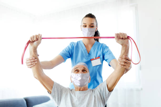 istock nurse doctor senior care exercise physical therapy ecercising help assistence retirement mask virus corona 1317992599