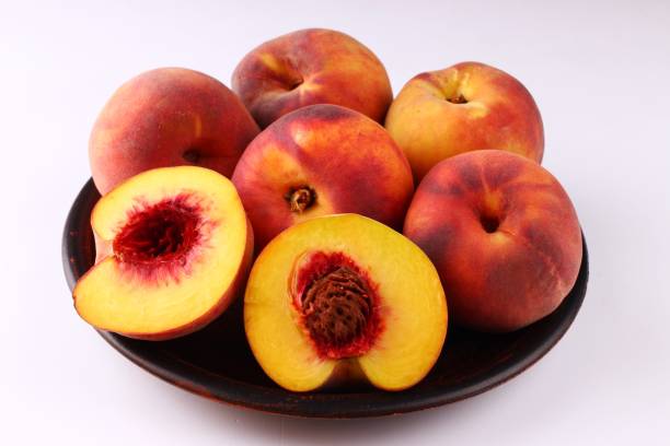 istock Peach on a white background in the plate 1317994339