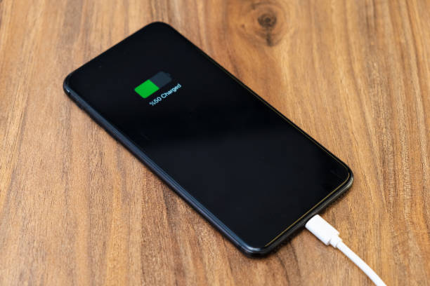 istock smartphone battery charging showing half charged battery on fast cable charger concept 1317995588