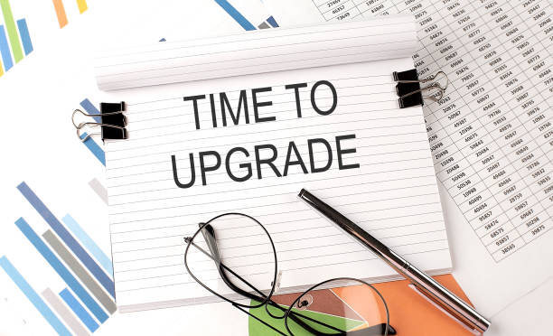 istock Notebook with text IME TO UPGRADE on table with charts,pen and glasses. 1317997013