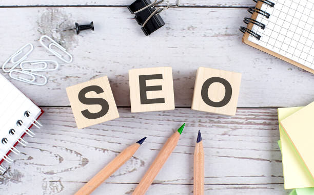 istock SEO text on wooden block with office tools on wooden background 1317997058