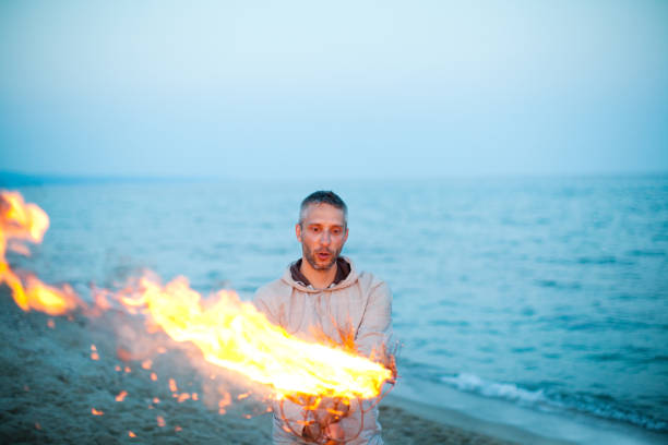 Young adult men making fire at the beach
