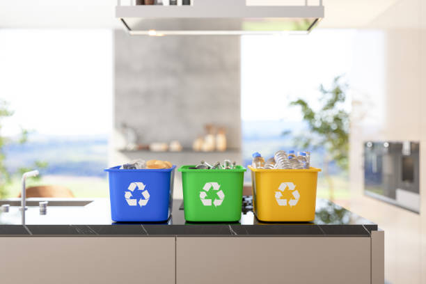 contenedores de reciclaje en la isla de la cocina con fondo de cocina borrosa - reciclaje fotografías e imágenes de stock