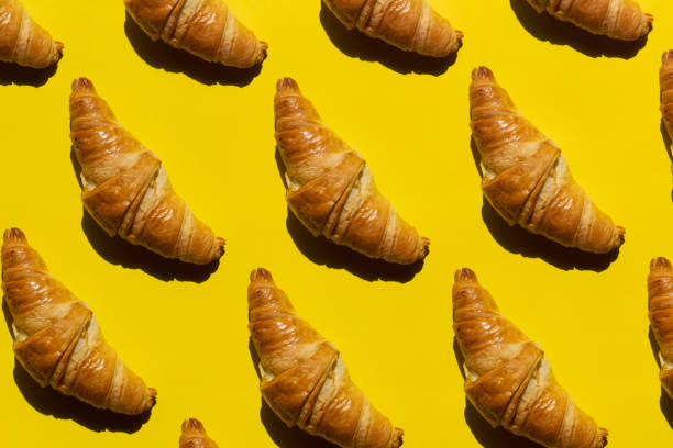 istock Freshly baked croissant on yellow background 1317998215