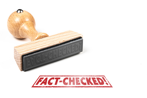 wooden rubber stamp and imprint with text FACT-CHECKED on white background, fact checking concept