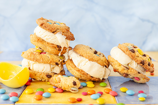 Vanilla ice cream sandwich with chocolate chip cookies and colorful chocolate lentils