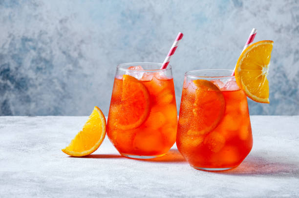 istock Spritz Cocktail in glasses with ice and orange slice on light blue background 1318000100