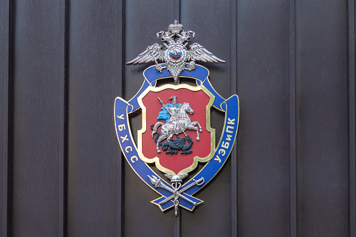 The coat of arms of the Office of Economic Security and Anti-Corruption is attached to the iron gates.
