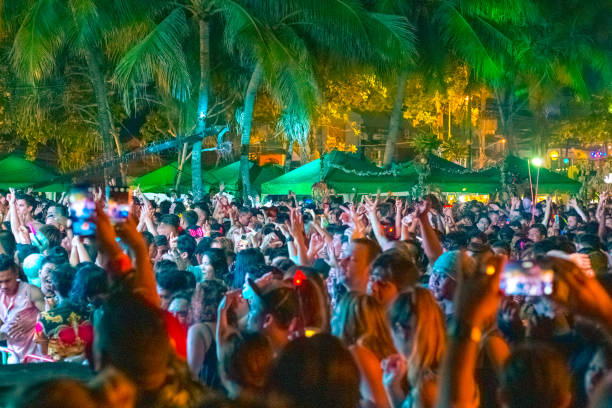 a crowd of young people dancing at night at the New Year's Eve celebration Phuket, Thailand-12.31.2018: a crowd of young people dancing at night at the New Year's Eve celebration on the beach in the tropics, blurred background phuket beach party stock pictures, royalty-free photos & images