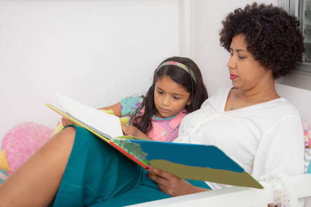 istock mother and daughter reading a book together 1318002015