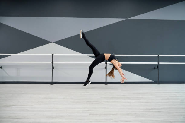 istock Woman doing wheel jump in dance hall. 1318003234