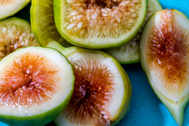 istock Whole and cut green figs, with honey. Foreground. On colorful background. 1318005116
