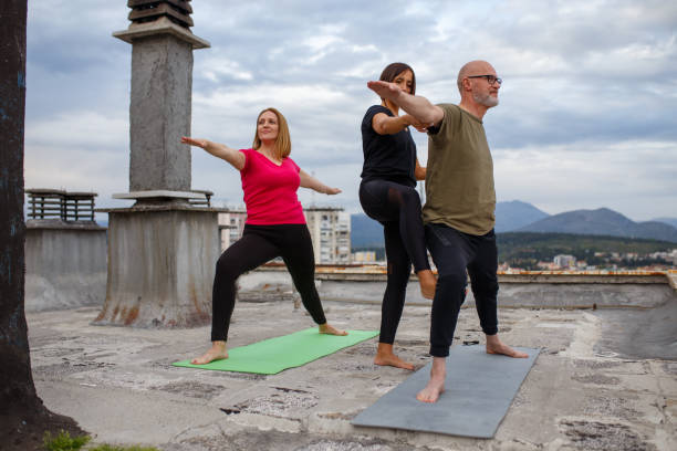 istock Professional Yoga Trainer Supporting Man  During Yoga Training 1318006350