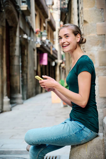 istock young attractive woman using smartphone and smiling 1318006814