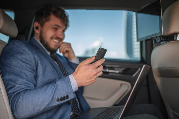 istock Young entrepreneur smiling while looking at his phone during business trip. 1318007700