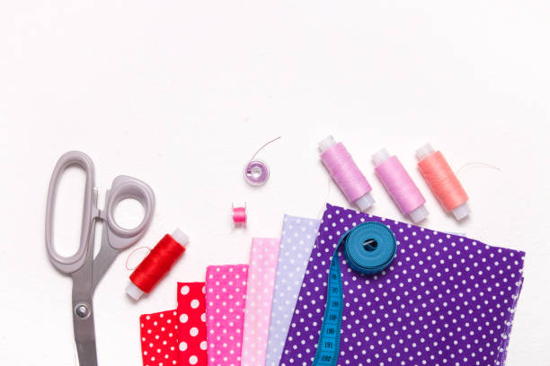 istock different colors of fabric with a pattern, scissors and spools of thread on a white background, blue measuring tape and accessories for sewing, copy space, top view, purple red and pink fabric 1318010200