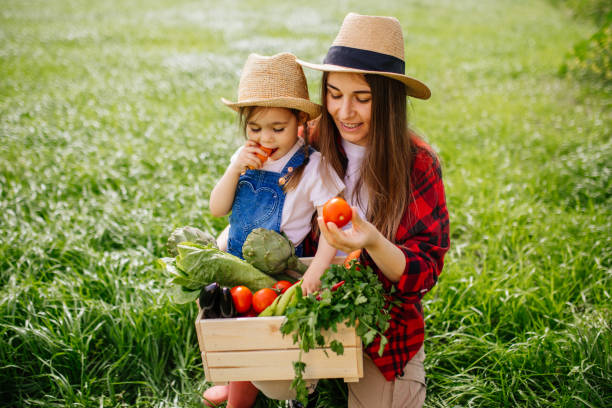 istock Mother and daughter with fresh vegetable in farm 1318010464