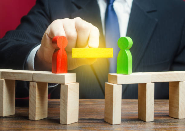 istock A man mediates in the negotiation process. Compromise and dispute resolution. Build bridges improve relationships. Communication mediation between conflicting parties. escape escalations of conflicts 1318010582