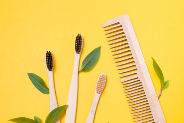 istock wooden combs and bamboo toothbrushes on a yellow background, protecting the environment from pollution concept, zero waste lifestyle, leaves as a symbol of natural materials 1318011508