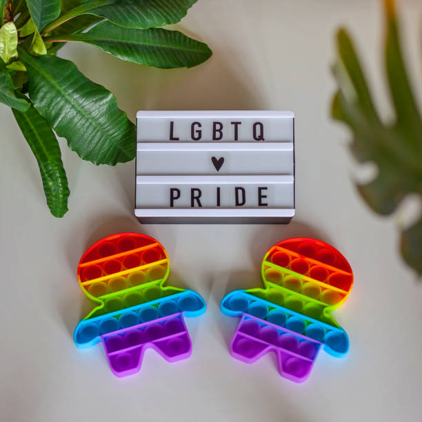 dos figuras inquietas con bandera arco iris de colores lgbtq, concepto de orgullo gay - lesbian gay man rainbow multi colored fotografías e imágenes de stock