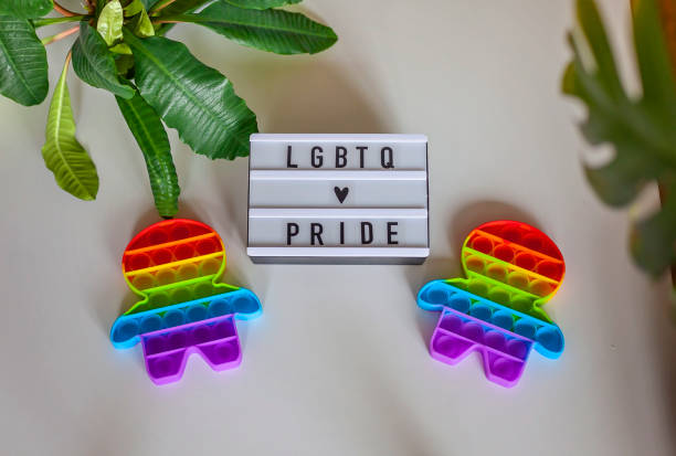dos figuras inquietas con bandera arco iris de colores lgbtq, concepto de orgullo gay - lesbian gay man rainbow multi colored fotografías e imágenes de stock