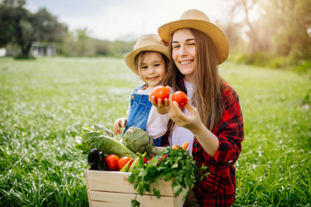 istock Mother and daughter with fresh vegetable in farm 1318011854