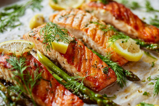 istock Baked salmon fillets with aromatic herbs and lemon on baking paper, focus on the portion inside 1318012638