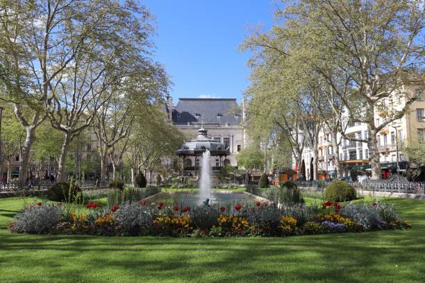 Jean Jaures Square in Saint Etienne Jet of water surrounded by a large green lawn on the Place Jean Jaurès, city of Saint Etienne, Loire department, France saint étienne photos stock pictures, royalty-free photos & images
